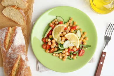 Photo of Delicious fresh chickpea salad served on white wooden table, flat lay