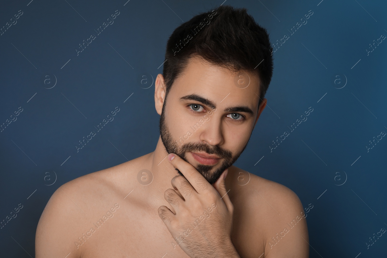 Photo of Handsome young man with beard after shaving on blue background