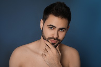 Photo of Handsome young man with beard after shaving on blue background