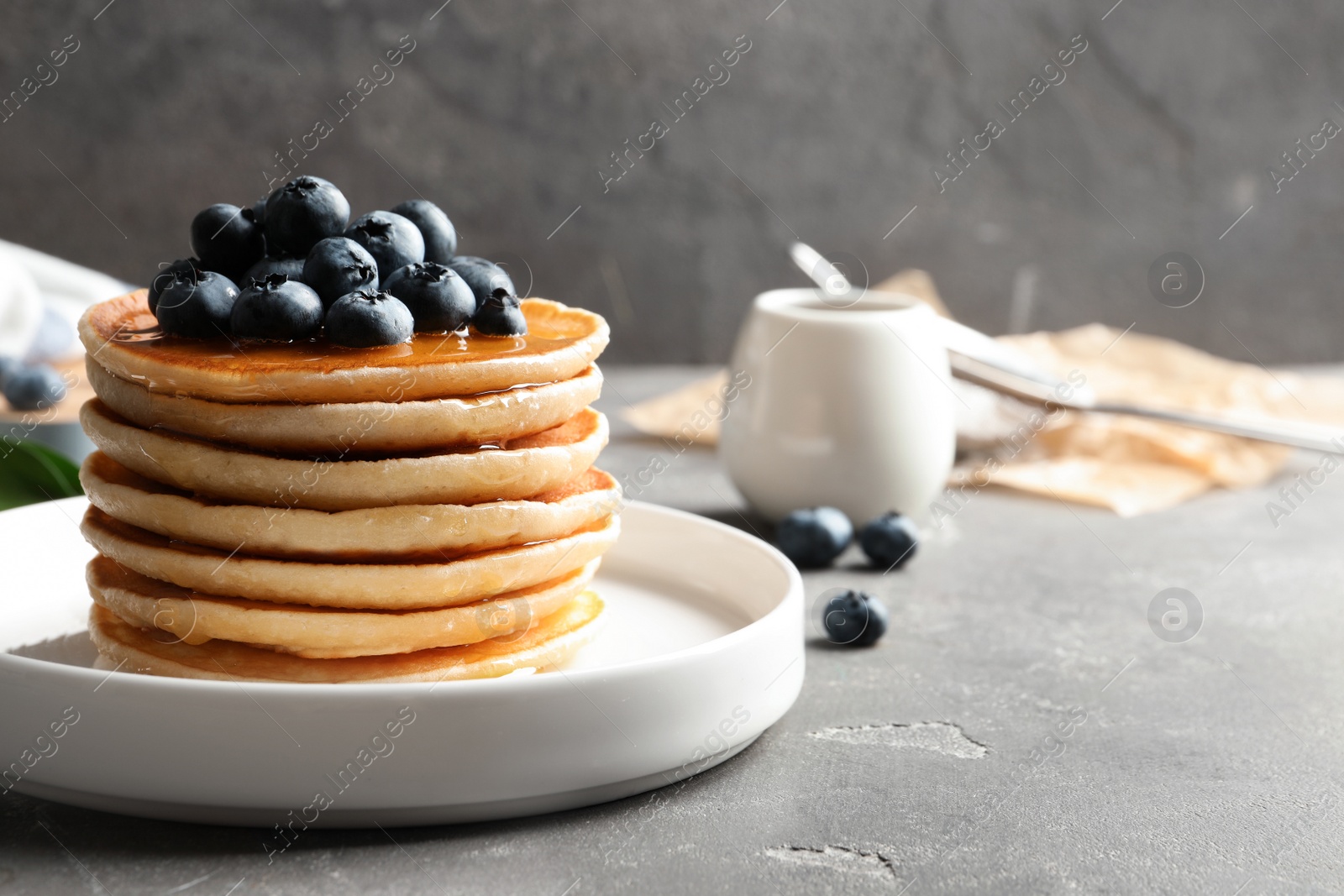 Photo of Plate with pancakes and berries on table