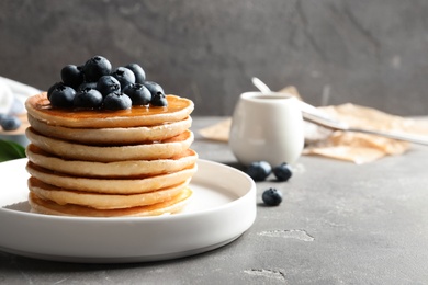 Photo of Plate with pancakes and berries on table