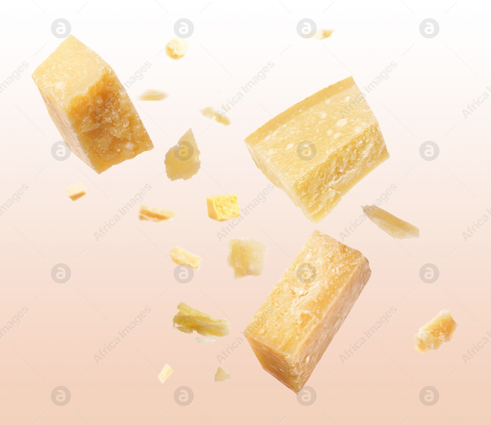 Image of Pieces of delicious parmesan cheese flying on color background