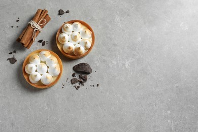 Photo of Tasty dessert. Tartlets with meringue served on light grey table, flat lay. Space for text