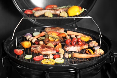 Photo of Barbecue grill with delicious cooked meat and vegetables, closeup