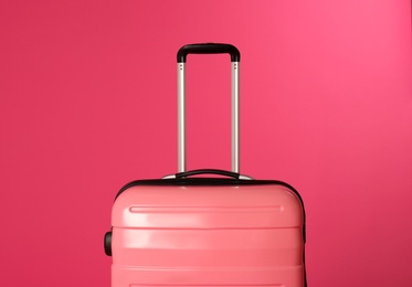 Photo of Stylish carry on suitcase on color background