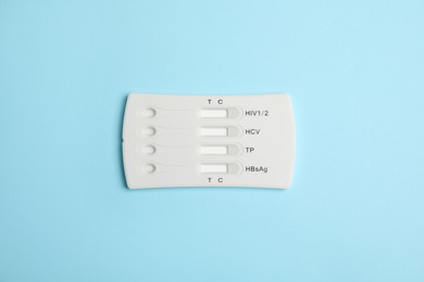 Photo of One disposable express test for hepatitis on light blue background, top view