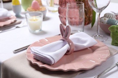 Festive table setting with napkin ring in shape of bunny ears, closeup. Easter celebration