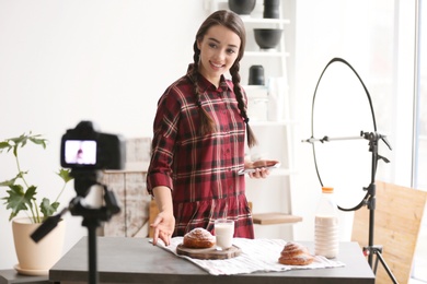 Young food blogger recording video on camera in studio