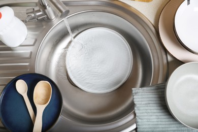 Washing plate in kitchen sink, above view