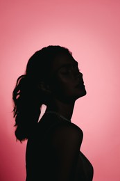 Silhouette of one woman on pink background