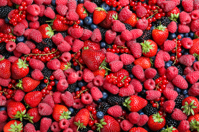 Photo of Mix of different ripe tasty berries as background, top view