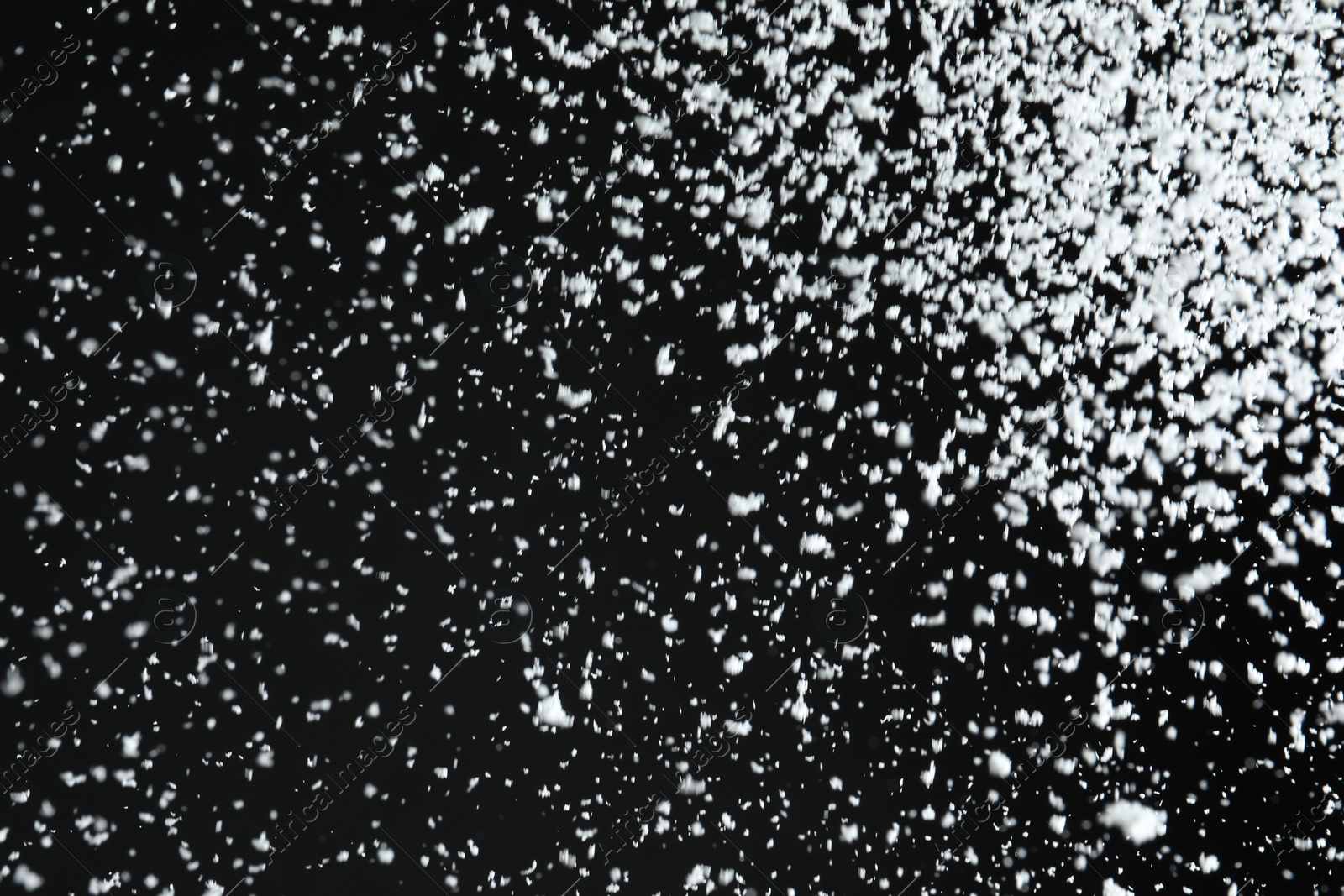 Photo of White snow falling down on black background