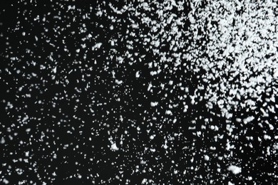 Photo of White snow falling down on black background