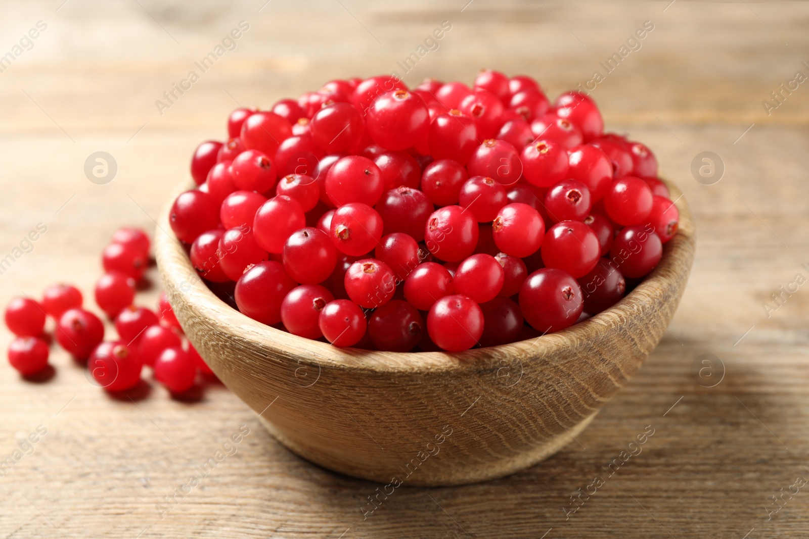 Photo of Ripe fresh cranberry on wooden table, closeup