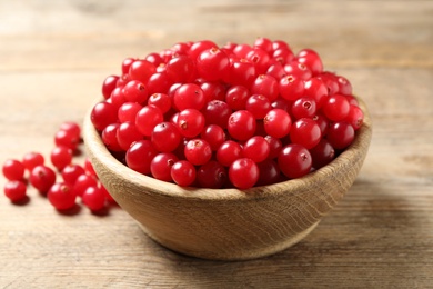 Photo of Ripe fresh cranberry on wooden table, closeup