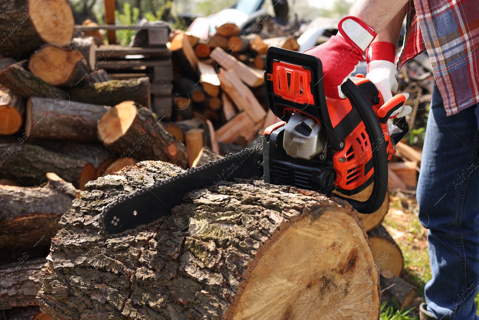 Photo of Man sawing wooden log on sunny day, closeup