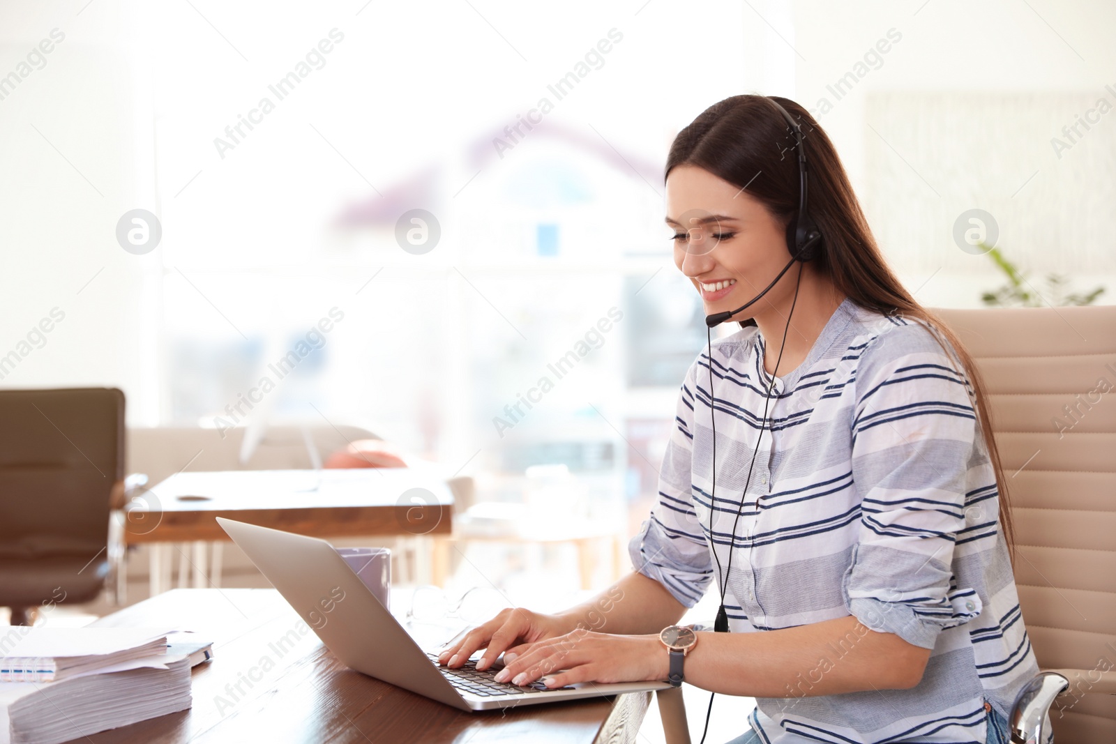 Photo of Young woman using video chat on laptop in home office