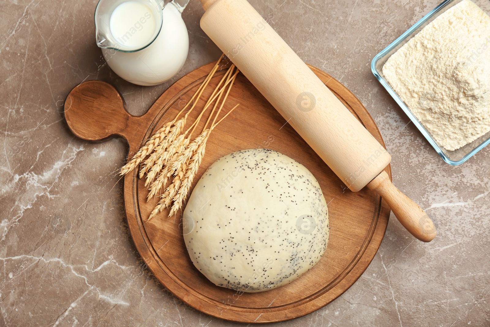 Photo of Composition of raw dough with poppy seeds on table