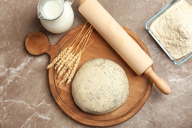 Composition of raw dough with poppy seeds on table