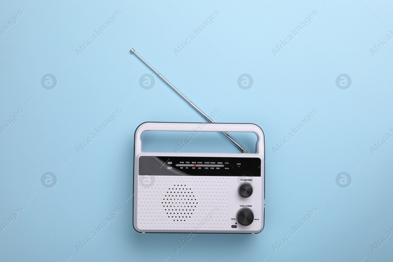 Photo of Retro radio receiver on light blue background, top view