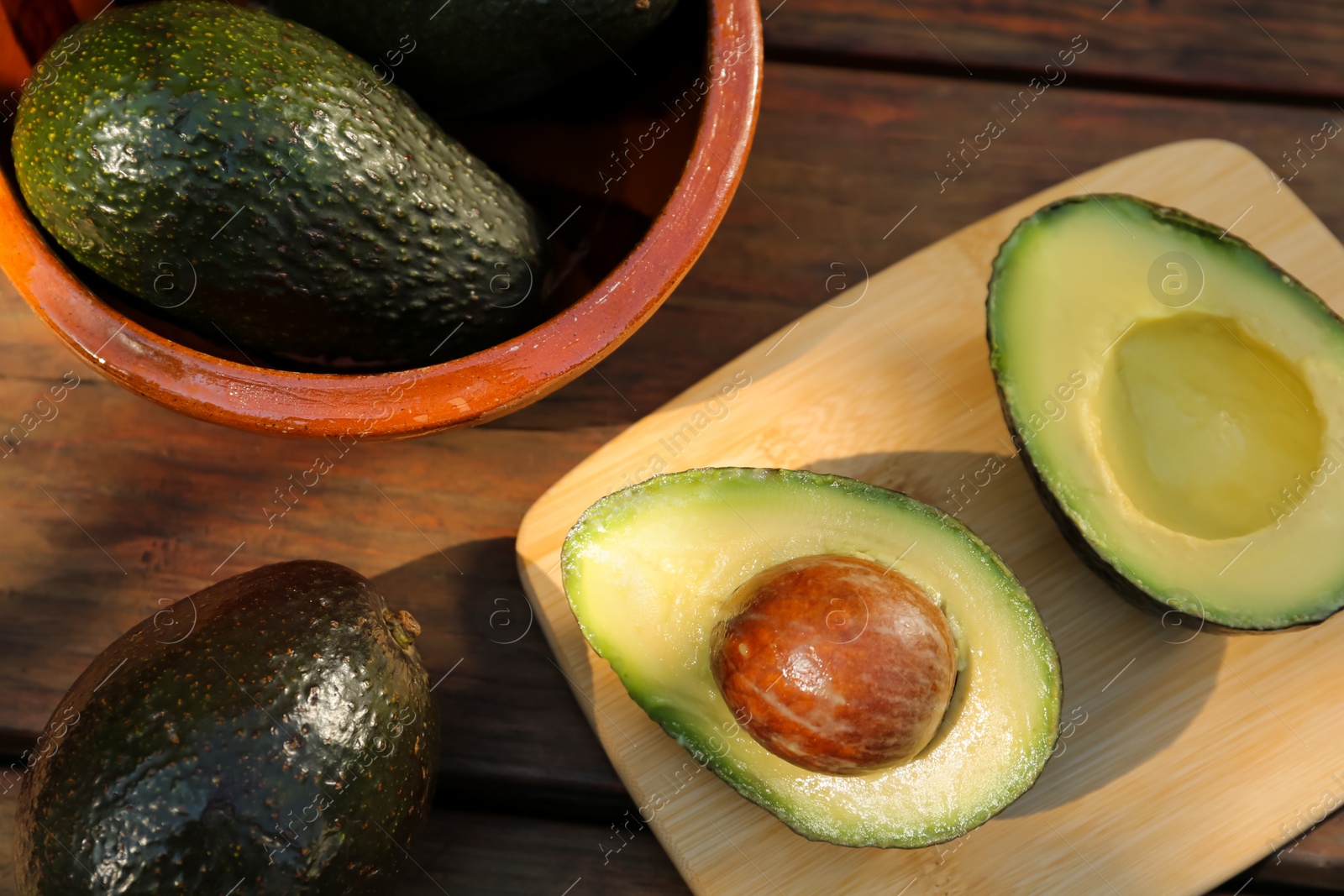 Photo of Tasty fresh avocados on wooden table, flat lay