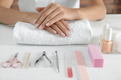 Photo of Woman waiting for manicure and tools on table, closeup. Spa treatment