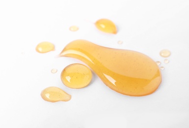 Photo of Drops of sweet honey on white background