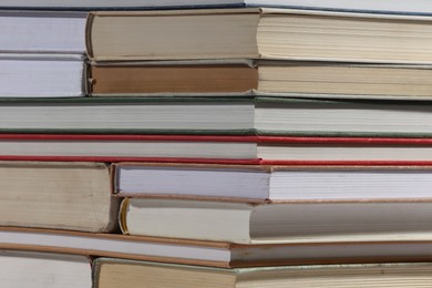 Photo of Stack of many different hardcover books as background, closeup