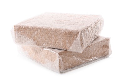 Cardboard boxes packed in bubble wrap on white background