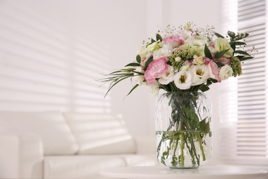 Photo of Bouquet of beautiful flowers on table in living room, space for text. Interior design