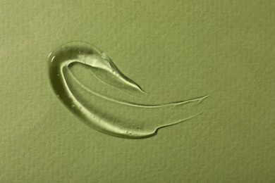 Photo of Sample of cosmetic gel on green background, top view