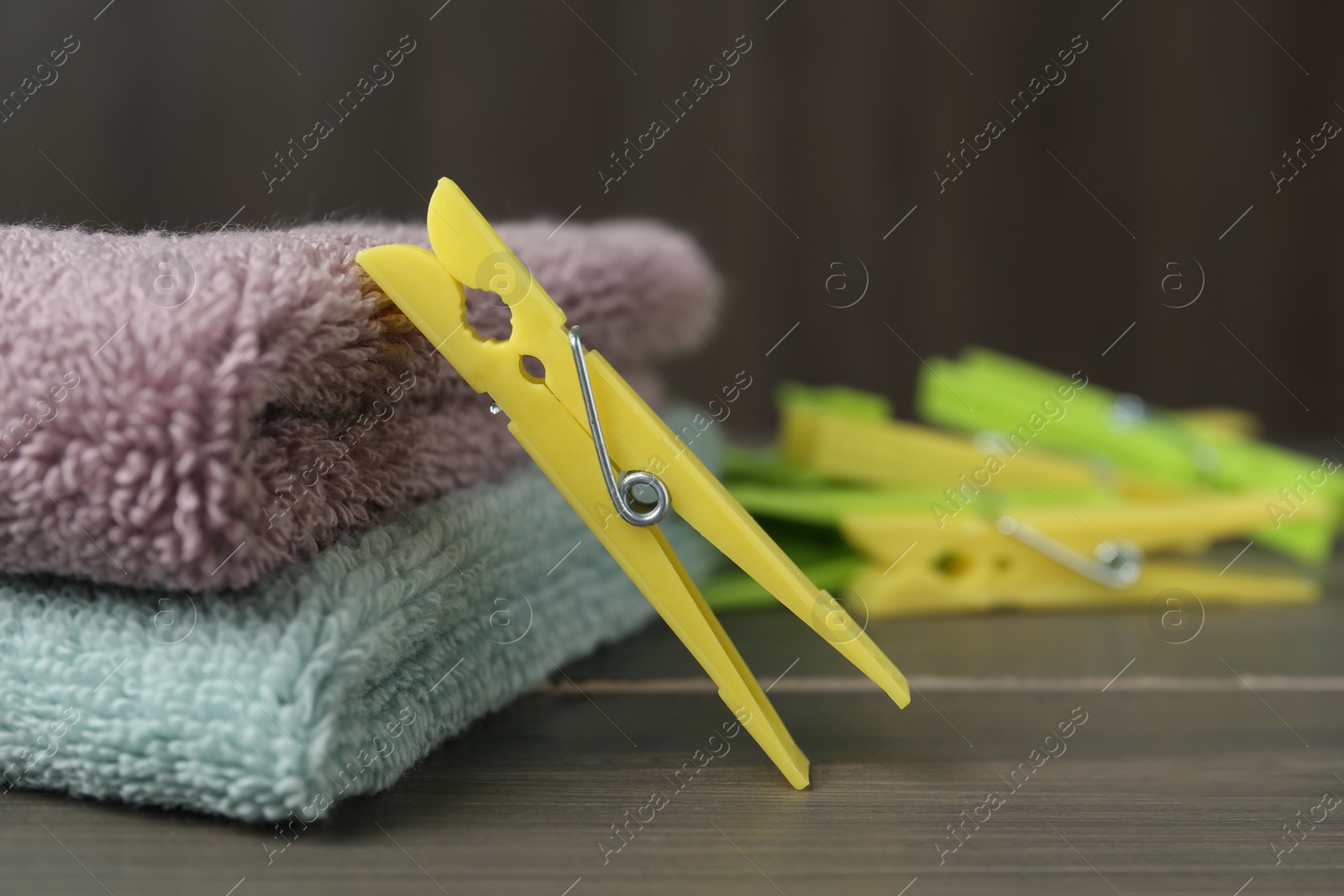 Photo of Clothespin and towels on wooden table. Space for text