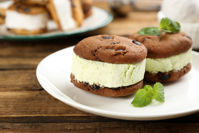 Photo of Sweet delicious ice cream cookie sandwiches on wooden table