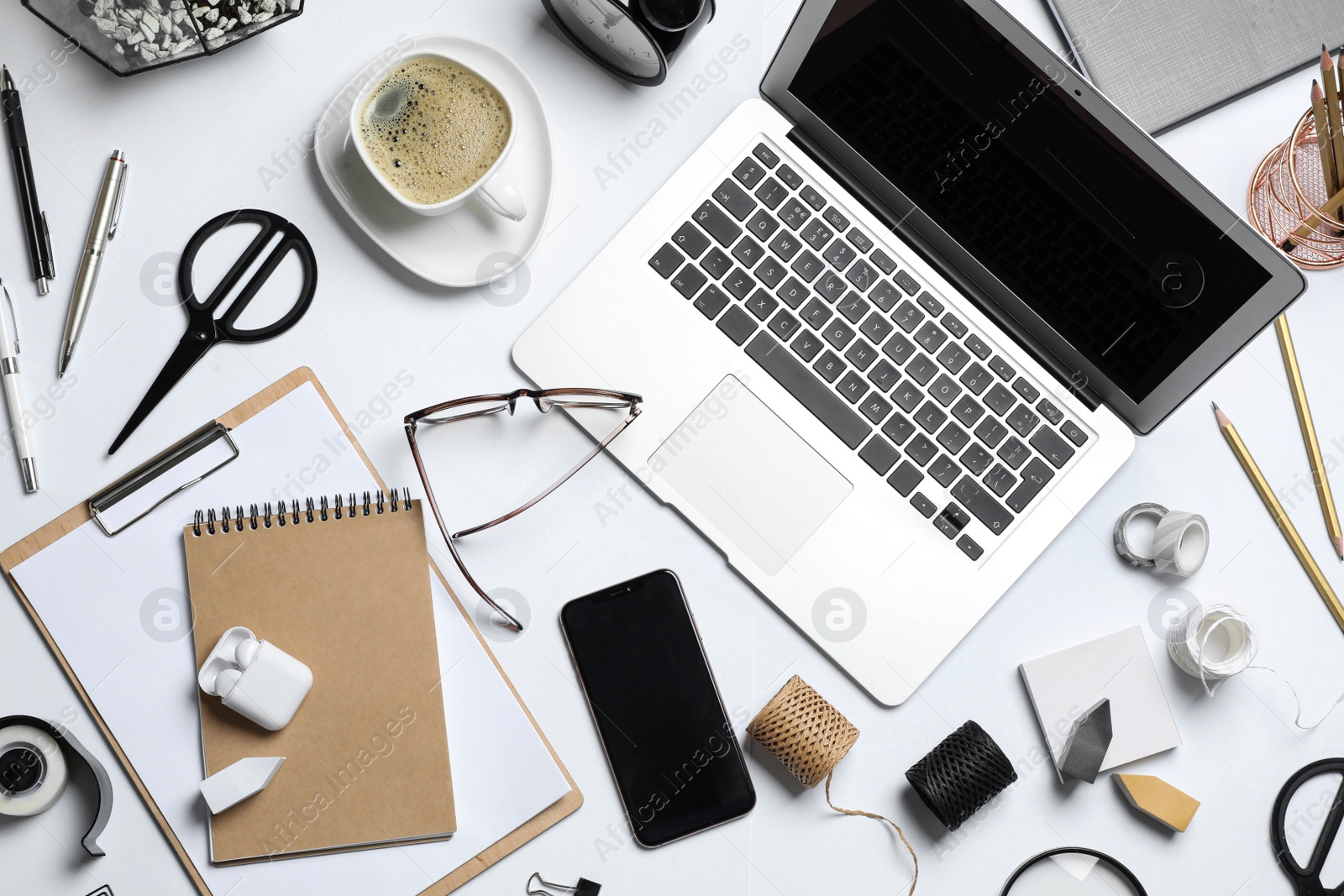 Photo of Flat lay composition with laptop, smartphone and stationery on white table. Designer's workplace