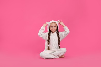 Photo of Cute girl wearing pajamas on pink background