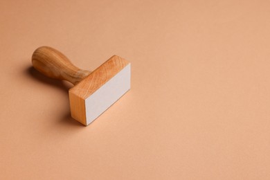 Photo of One wooden stamp tool on light brown background, space for text
