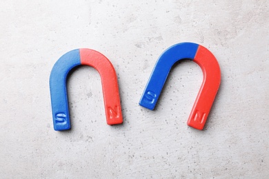 Photo of Red and blue horseshoe magnets on grey background, top view