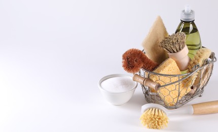 Photo of Set of different cleaning supplies in basket on white background