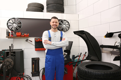 Mechanic near wheel balancing machine at tire service