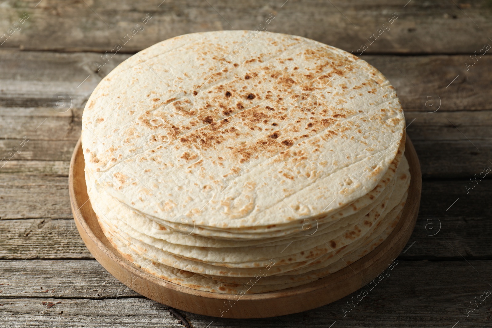 Photo of Stack of tasty homemade tortillas on wooden table