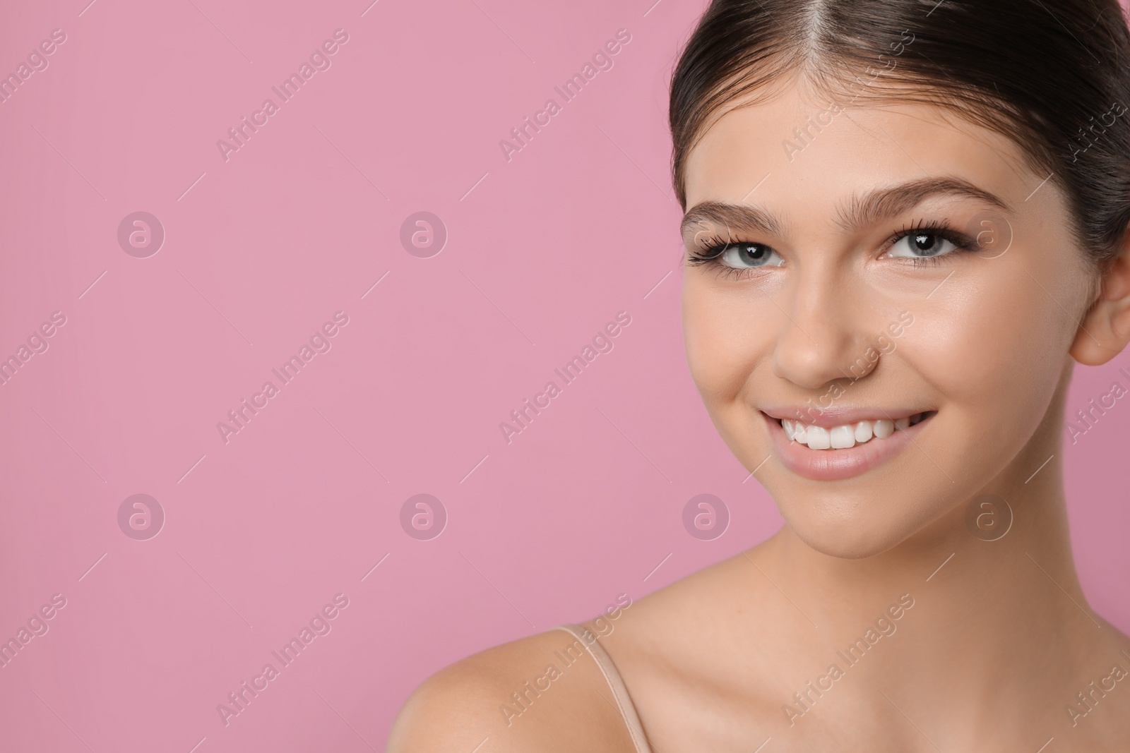 Photo of Pretty girl on pink background, space for text. Beautiful face with perfect smooth skin