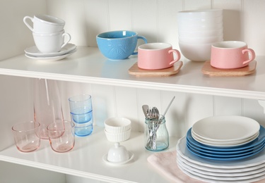 White shelving unit with set of dishware