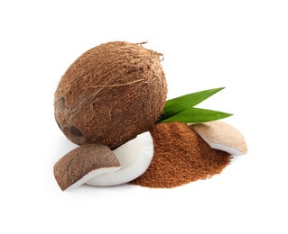 Ripe coconuts and pile of brown sugar on white background