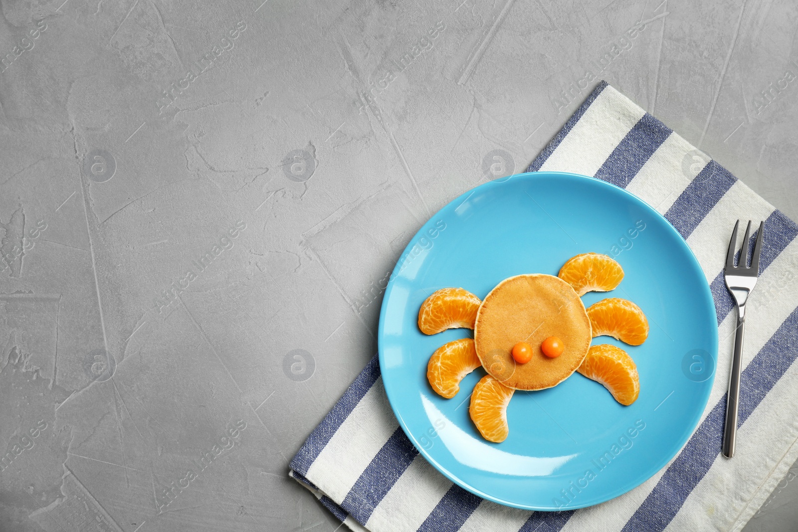 Photo of Flat lay composition with pancake in form of crab on grey background. Creative breakfast ideas for kids