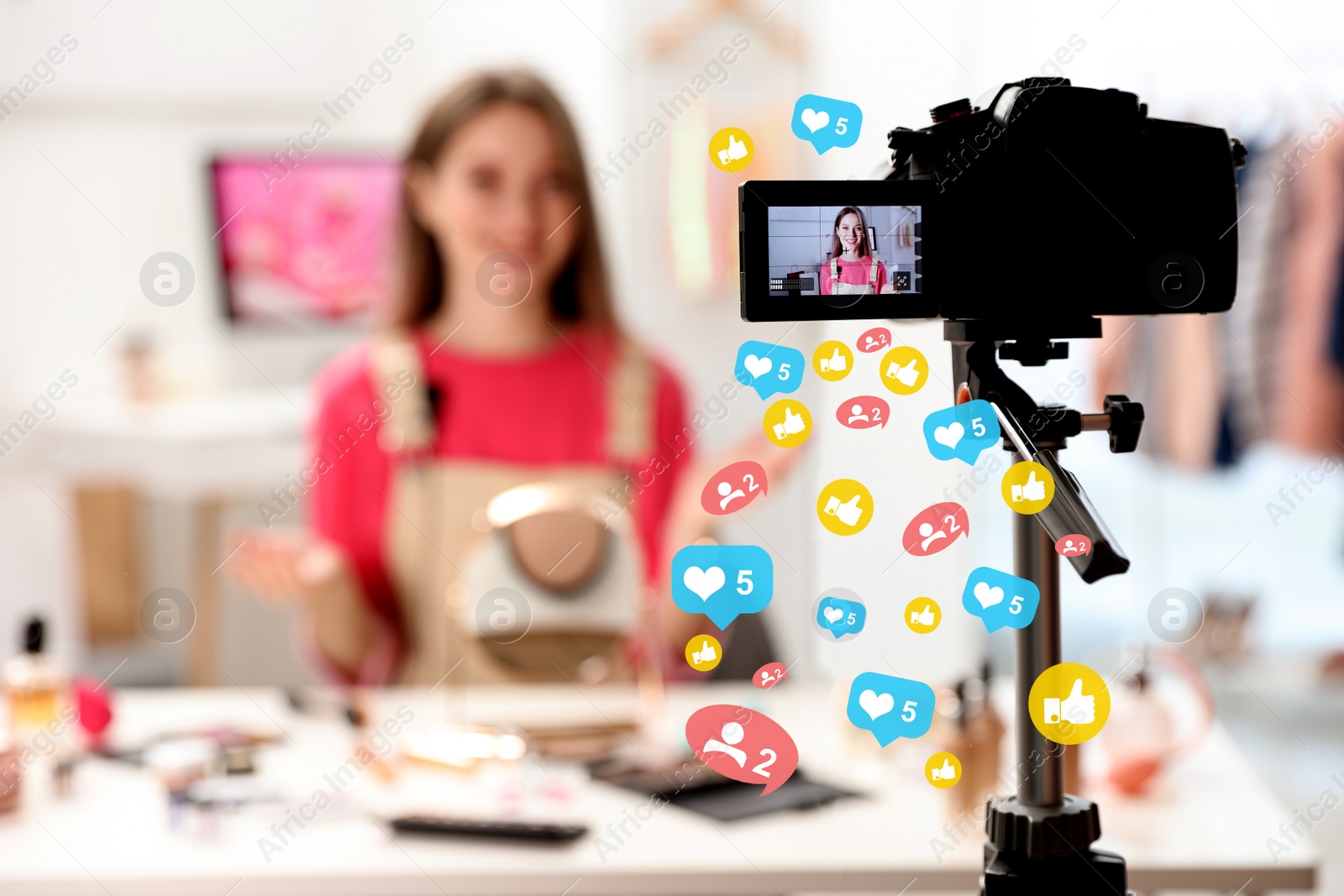 Image of Beauty blogger filming make up tutorial at home, focus on camera