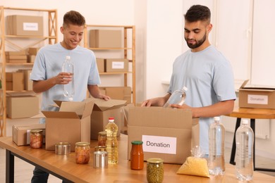 Photo of Volunteers packing food products at table in warehouse