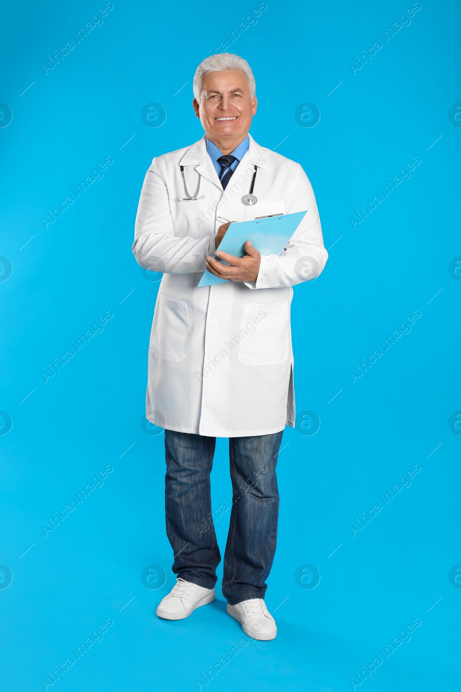 Photo of Senior doctor with clipboard on light blue background