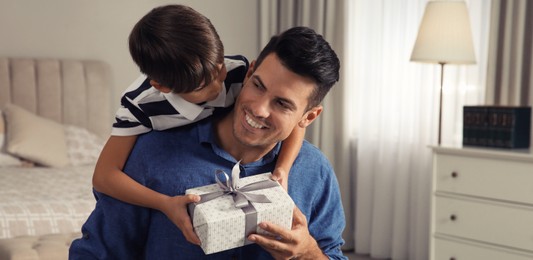 Photo of Man receiving gift for Father's Day from his son at home