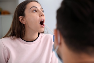 Doctor taking sample for DNA test from woman in clinic