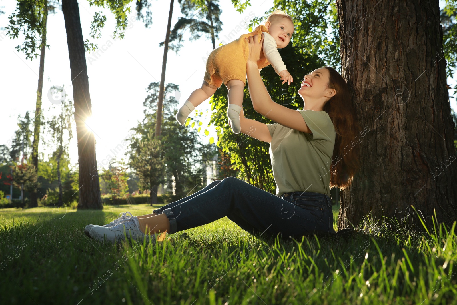 Photo of Beautiful mother with her cute daughter spending time together in park on summer day